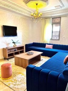 a living room with blue couches and a tv at Marakech home in Marrakesh