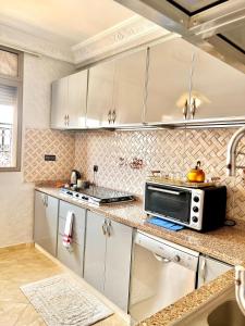 a kitchen with white cabinets and a microwave at Marakech home in Marrakesh