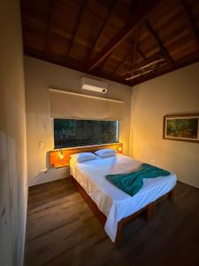 a bedroom with a large bed with a window at Puxadinho São Pedro in São Pedro +32 photos