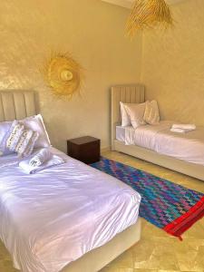 a bedroom with two beds and a rug at Marakech home in Marrakesh