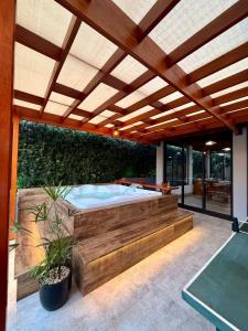 a hot tub in a patio with a wooden pergola at Puxadinho São Pedro in São Pedro