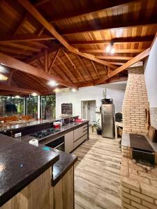 a large kitchen with wooden ceilings and wooden floors at Puxadinho São Pedro in São Pedro +30 photos