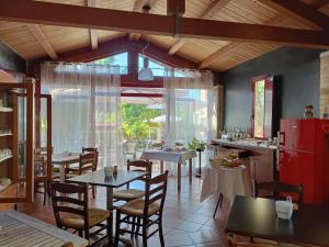 a dining room with tables and chairs and a red refrigerator at casale Don Ambrosio in Silvi Marina