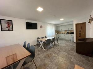 a living room with a table and chairs and a kitchen at Casa Militaru in Murighiol