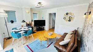 a living room with a couch and a table at Inviting 2 Bed Guest House steps away from Ascot Racecourse 3 mins drive, 5 mins to Legoland, 12 mins to Windsor Castle Perfect for families & racegoers alike in Winkfield