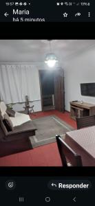 a living room with a couch and a table at Ap confortável in Tramandaí