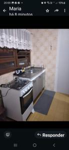 a picture of a kitchen with a stove and a sink at Ap confortável in Tramandaí