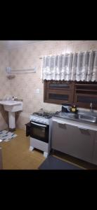 a kitchen with a sink and a stove top oven at Ap confortável in Tramandaí +17 photos