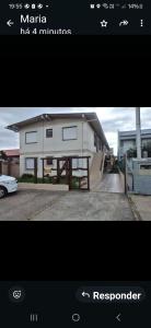a picture of a house with a car parked in a driveway at Ap confortável in Tramandaí
