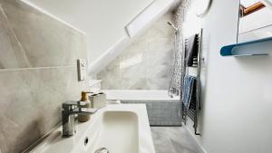 a bathroom with a sink and a bath tub at Inviting 2 Bed Guest House steps away from Ascot Racecourse 3 mins drive, 5 mins to Legoland, 12 mins to Windsor Castle Perfect for families & racegoers alike in Winkfield