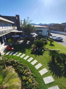 a garden with chairs and tables and a building at Hotel Itajara in Jaraguá do Sul