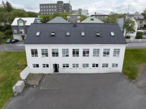 a large white building with a black roof at Hostel Fjordur in Hafnarfjörður
