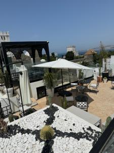 a patio with an umbrella and tables and chairs at Riad M'Barka in Tangier