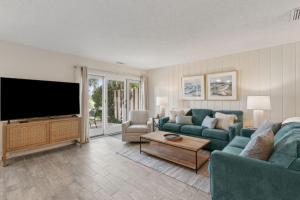 a living room with a large flat screen tv at 2098 Beach Wood in Amelia Island +62 photos