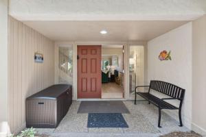 a porch with a bench and a red door at 2098 Beach Wood in Amelia Island