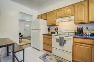 a kitchen with wooden cabinets and a white refrigerator at Alder Nest Cozy Retreat w Fire Pit & Workspace in Colorado Springs