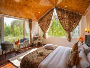 a bedroom with a large bed and a large window at Moustache Pahalgam in Pahalgām