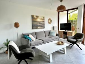 Una sala de estar con un sofá y sillas y un televisor. en Vakantie Zeeland, en Brouwershaven