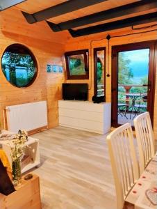 a living room with a television and a table and chairs at 479 Tiny House, Domeniul von Agodt in Bradu