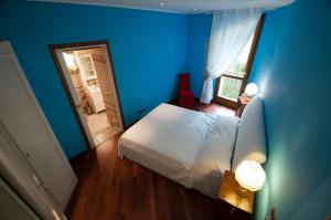 ヴィットリオ・ヴェネトにあるResidenza Venezia Cortinaの青いベッドルーム(ベッド1台、鏡付)