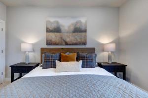 een slaapkamer met een groot bed met 2 nachtkastjes en 2 lampen bij Mayflower Lakeside Retreat in Cranmer