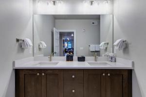 een badkamer met twee wastafels en een grote spiegel bij Mayflower Lakeside Retreat in Cranmer +36 foto's