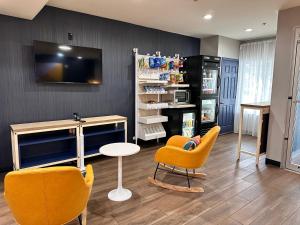 a room with chairs and a table and a tv at Spark by Hilton Guilford in Guilford