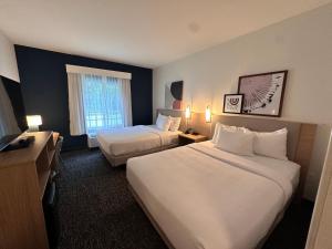 a hotel room with two beds and a window at Spark by Hilton Guilford in Guilford