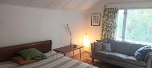 a bedroom with a bed and a couch and a window at Hyvän Elämän Koulun huoneisto Good Life Homestay Apartment in Ahmovaara