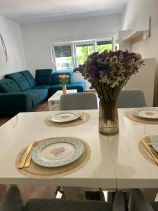 a living room with a table with plates and flowers on it at Stan na dan Ana in Prozor