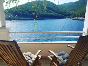 two chairs on a porch with a view of a lake at Jube vacation in Žrnovo