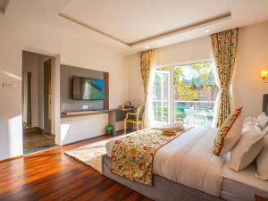 a bedroom with a large bed and a large window at Moustache Pahalgam in Pahalgām
