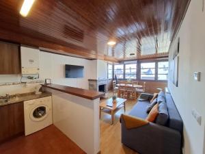 a living room with a blue couch and a kitchen at Stone, wifi, pet-friendly y garage - Arafita Apartamentos in Formigal