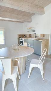 a kitchen with a table and two white chairs at Kaikna Podere Evolutivo in Montescudaio +34 photos