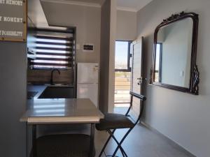 cocina con mesa, silla y espejo en Arum Cove Bloubergstrand, en Cape Town