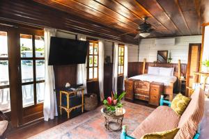 a bedroom with a bed and a flat screen tv at Casa Acuario Boutique Hotel in Bocas Town
