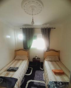 a bedroom with two beds and a window at Nearest apartement to the airport for comfortort in Zemmour Touirza