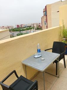 a table and chairs on a balcony with a bottle of water at Nearest apartement to the airport for comfortort in Zemmour Touirza