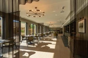 a restaurant with tables and chairs and a chandelier at Bailiffgate Hotel in Alnwick