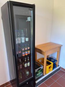 a refrigerator filled with lots of drinks next to a table at Klosterhof Neustadt am Main in Neustadt am Main