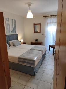 a bedroom with a large bed and a window at SOLMAR HOUSE in Flogita