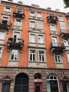 a large brick building with many windows on it at Cocon au cœur de Strasbourg in Strasbourg +3 photos