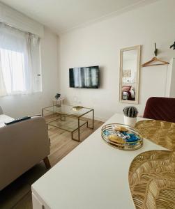 a living room with a couch and a table at Le boudoir Béthunois - Appart hôtel centre - all confort in Béthune +4 photos
