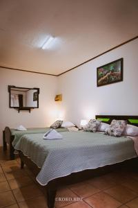 a bedroom with two beds and a mirror on the wall at Hotel Santa Fe B&B in Monteverde Costa Rica