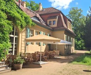 a table with an umbrella in front of a house at Pension - Kavaliershaus Krumke - Schlüsseltresor - Kein TV in Krumke
