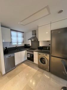 a kitchen with a stainless steel refrigerator and a dishwasher at CC8 VI by ZANIS in Torrevieja