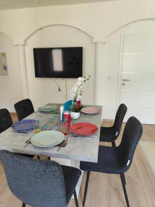 a dining room table with chairs and a television at Ferienwohnung Landliebe, nahe Jennersdorf und Therme in Windisch Minihof