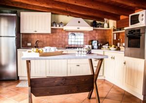 kuchnia z białymi szafkami i dużą wyspą w nim w obiekcie B&B Porta Bagni w mieście Sciacca