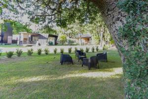 a group of chairs sitting in the grass under a tree at REFUGIO URBANO RINCON Casa Premium in Colastiné