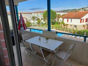a table and chairs on a balcony with a view at Appartement du Golf de Ciboure in Ciboure